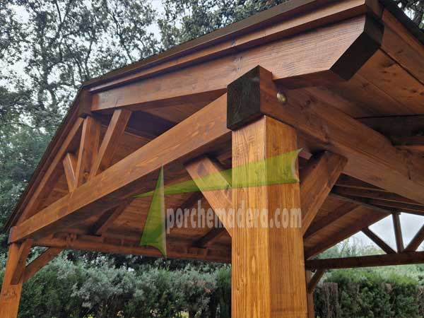Cenador de madera con cerchas en jardín rustico