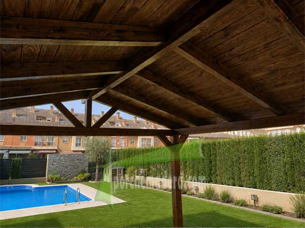 Cenador de madera a dos aguas con vistas al jardin desde el interior