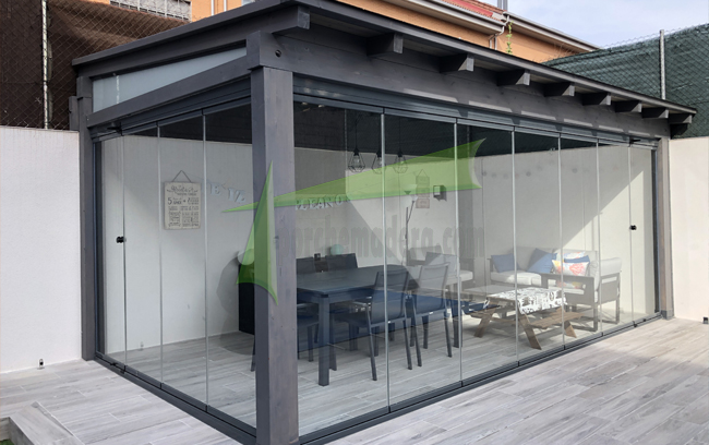 porche de madera con cortinas de cristal