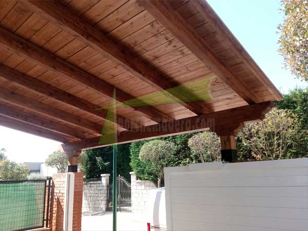 Garaje de madera apoyado sobre el muro de la fachada